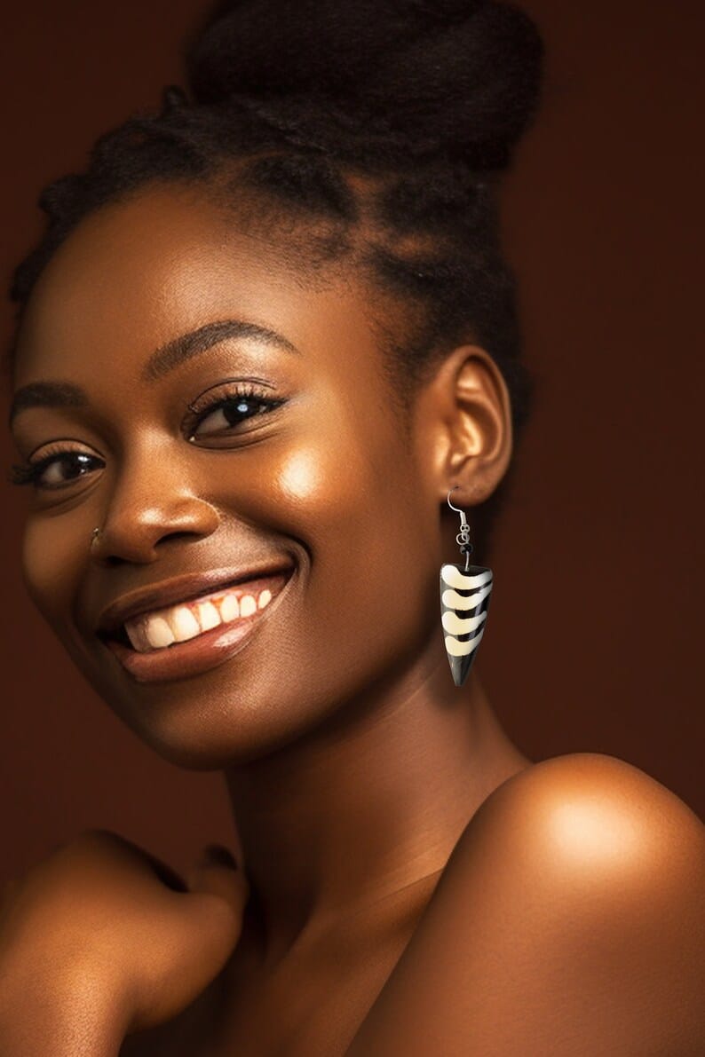 These eye-catching earrings feature a distinct tooth shaped profile, crafted from ethically sourced cow bone.